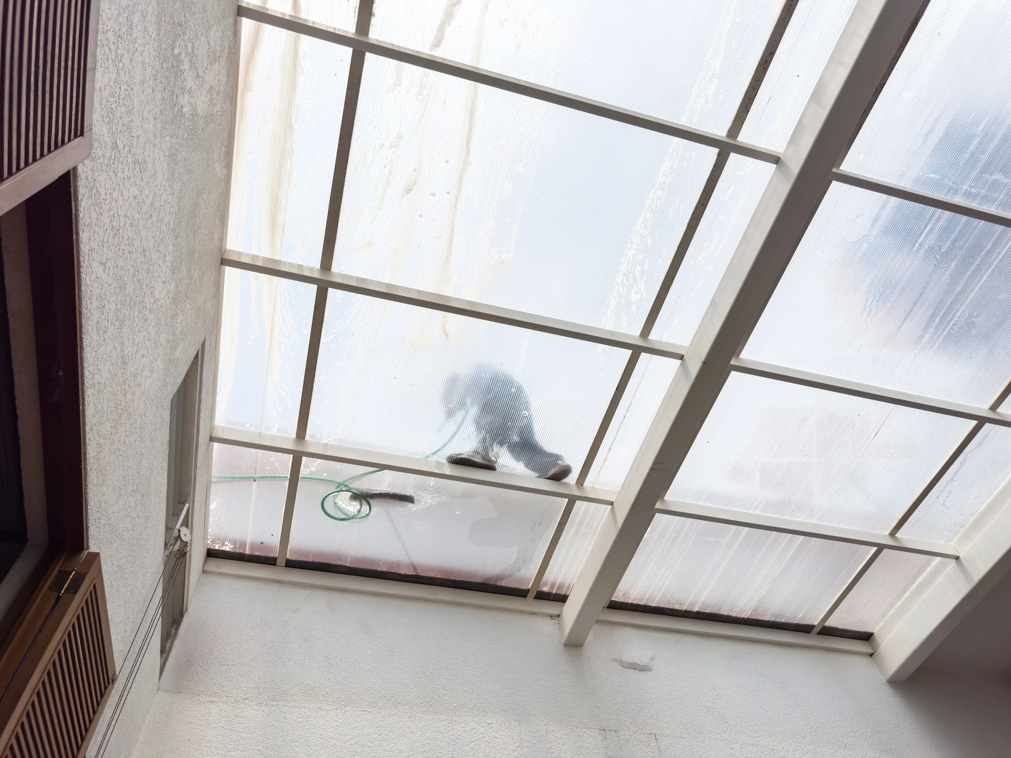 Technician cleaning exterior glazing at height